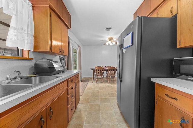 kitchen with stainless steel fridge, ceiling fan, and sink