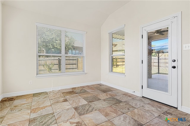 empty room with a wealth of natural light and lofted ceiling