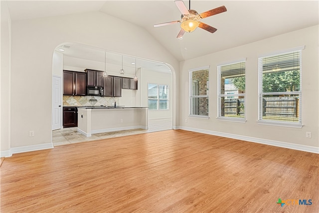 unfurnished living room featuring ceiling fan, light hardwood / wood-style floors, and lofted ceiling