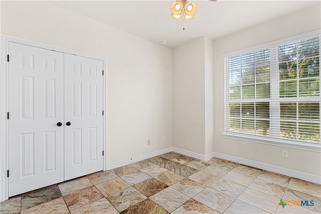 unfurnished room featuring ceiling fan and a healthy amount of sunlight