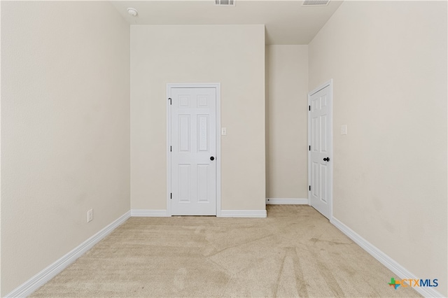 spare room featuring light carpet