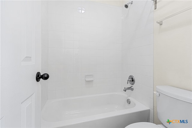 bathroom with tiled shower / bath combo and toilet