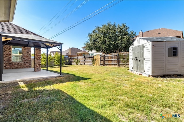 view of yard with a gazebo, a storage shed, and a patio area