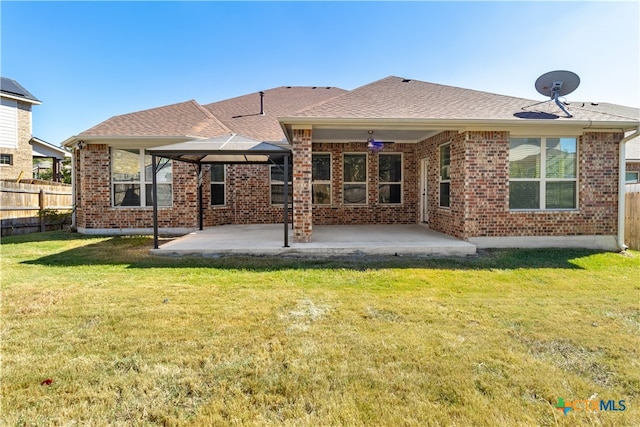 back of property with a lawn and a patio area