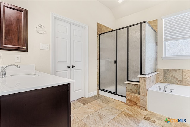 bathroom featuring vanity, separate shower and tub, and lofted ceiling