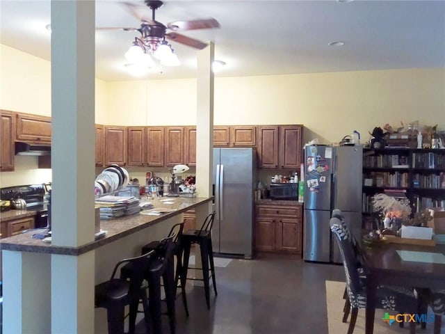 618 Pecos St, Lockhart, TX 78644 - kitchen featuring range, freestanding refrigerator, ceiling fan, black microwave, and stainless steel fridge