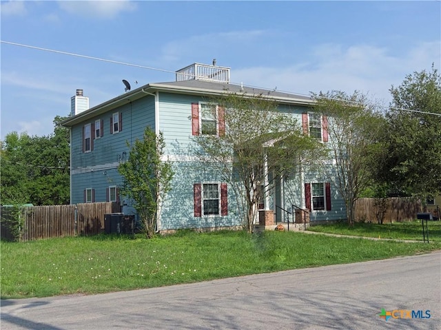 618 Pecos St, Lockhart, TX 78644 - view of front of property with central AC unit, a chimney, fence, and a front lawn