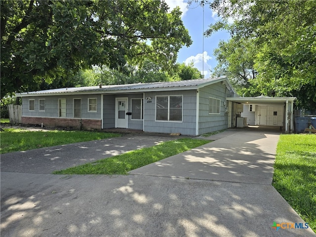 220 Davis Ave, Port Lavaca, TX 77979 - ranch-style home with driveway, a carport, metal roof, and a front yard