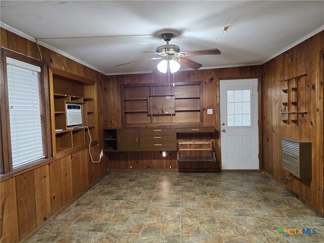 220 Davis Ave, Port Lavaca, TX 77979 - unfurnished dining area with heating unit, wooden walls, ceiling fan, ornamental molding, and stone finish floors
