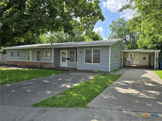 220 Davis Ave, Port Lavaca, TX 77979 - view of front of home featuring driveway, a carport, and metal roof