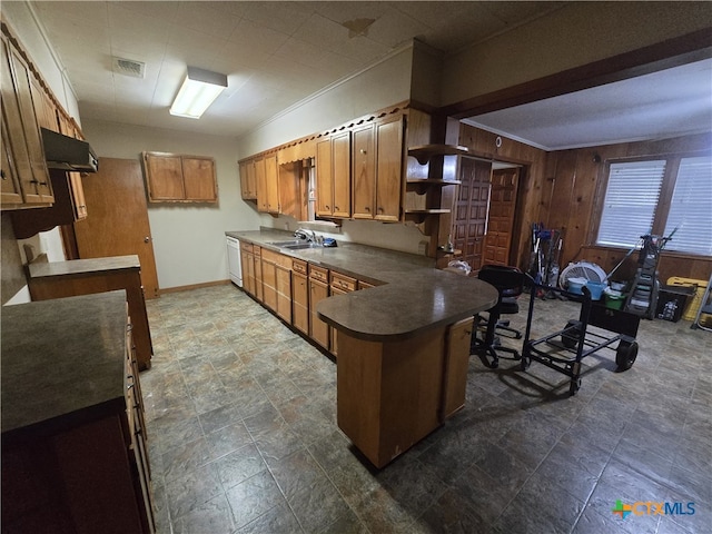 220 Davis Ave, Port Lavaca, TX 77979 - kitchen with a peninsula, white dishwasher, wood walls, dark countertops, and brown cabinets