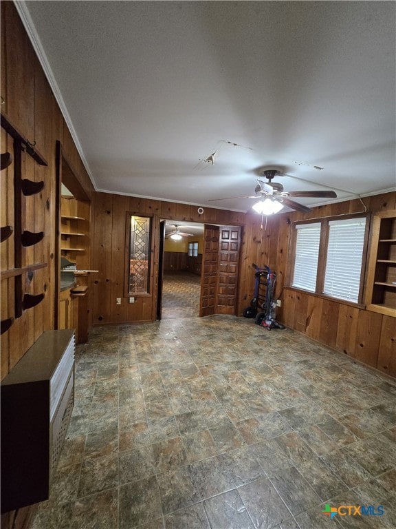 220 Davis Ave, Port Lavaca, TX 77979 - unfurnished living room featuring a ceiling fan, wooden walls, and stone finish floors