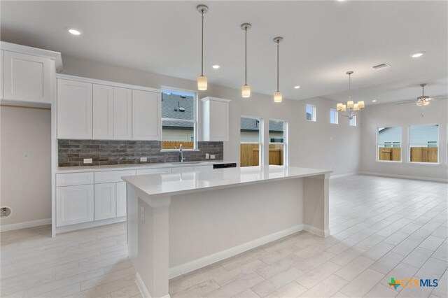 kitchen featuring white cabinets, sink, a kitchen island, and ceiling fan with notable chandelier