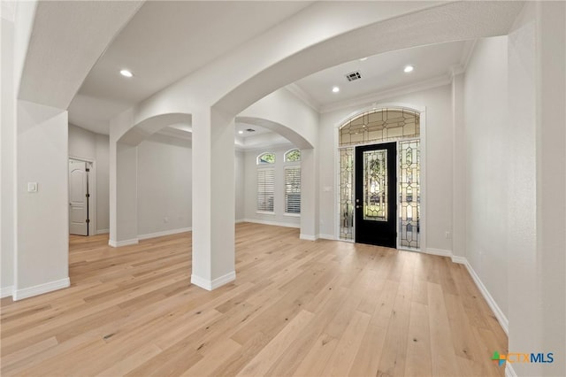 entrance foyer with ornamental molding and light wood-type flooring