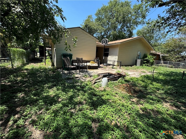 back of property with a patio and an outdoor fire pit