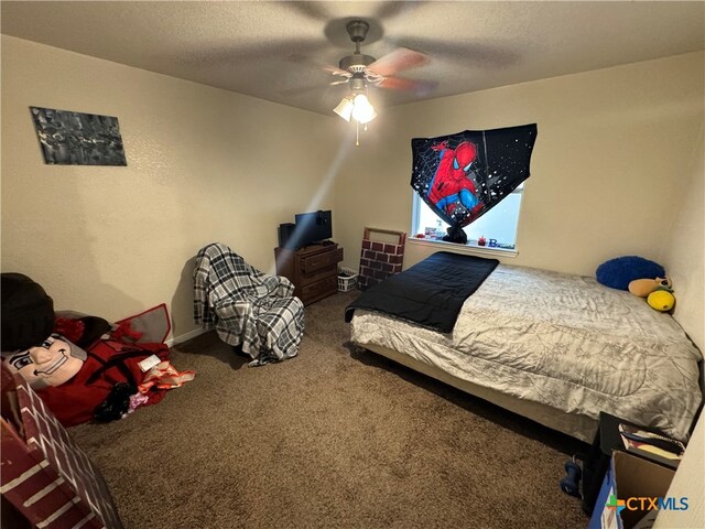 carpeted bedroom with ceiling fan and a textured ceiling