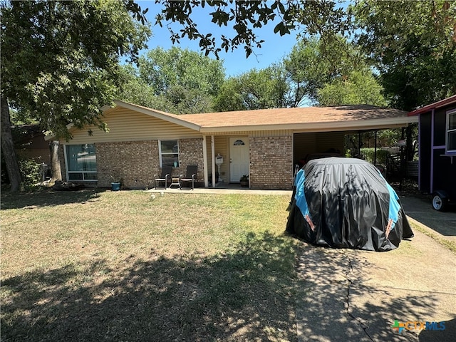 ranch-style home featuring a front lawn and a carport