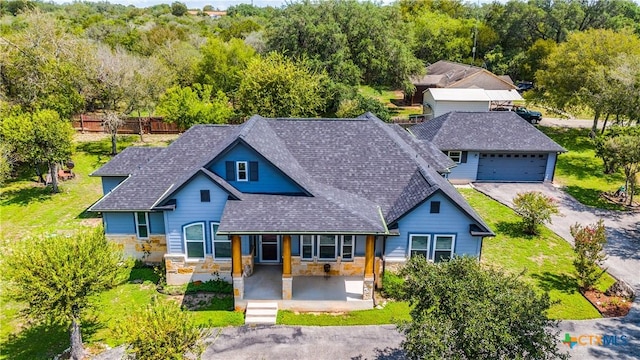 425 County Road 3830, San Antonio, TX 78253 - view of front of property with stone siding, covered porch, a shingled roof, a garage, and fence