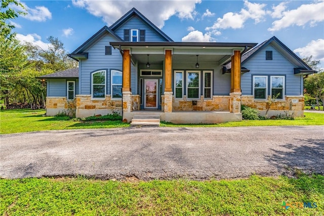 425 County Road 3830, San Antonio, TX 78253 - craftsman-style home featuring stone siding, a front lawn, and covered porch