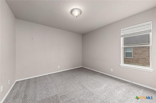 empty room featuring a textured ceiling and carpet