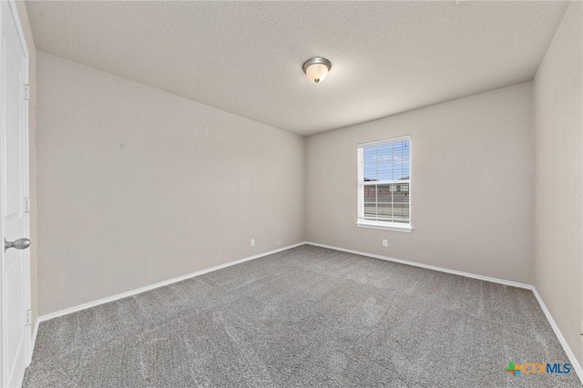 unfurnished room with a textured ceiling and carpet flooring