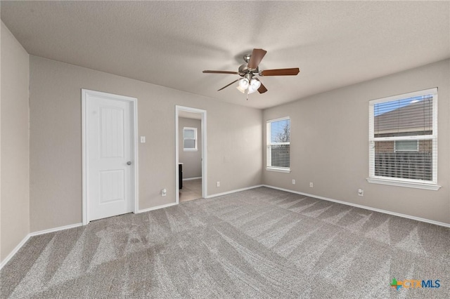 unfurnished room featuring ceiling fan, carpet floors, and a textured ceiling