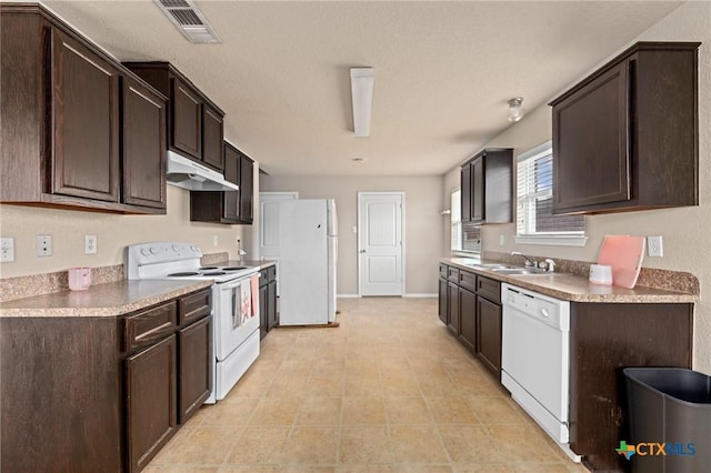 kitchen with dark brown cabinets, sink, light tile patterned floors, and white appliances