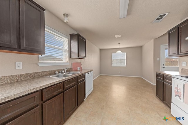 kitchen with dark brown cabinetry, sink, pendant lighting, and white appliances