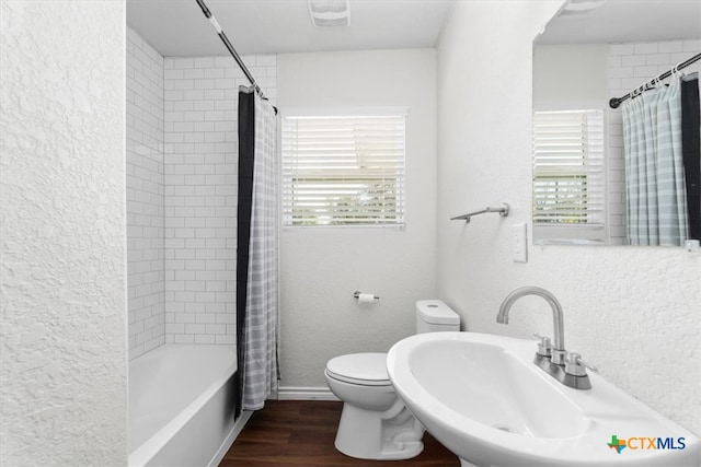 full bathroom featuring hardwood / wood-style flooring, sink, toilet, and shower / bathtub combination with curtain