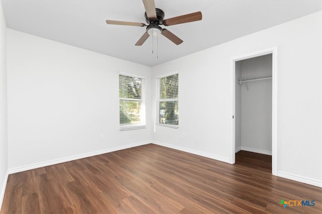 unfurnished bedroom featuring dark hardwood / wood-style flooring, ceiling fan, and a closet