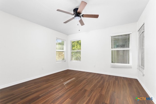 unfurnished room featuring dark wood-type flooring and ceiling fan