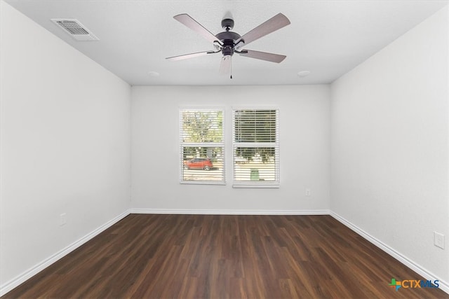 spare room featuring dark wood-type flooring and ceiling fan