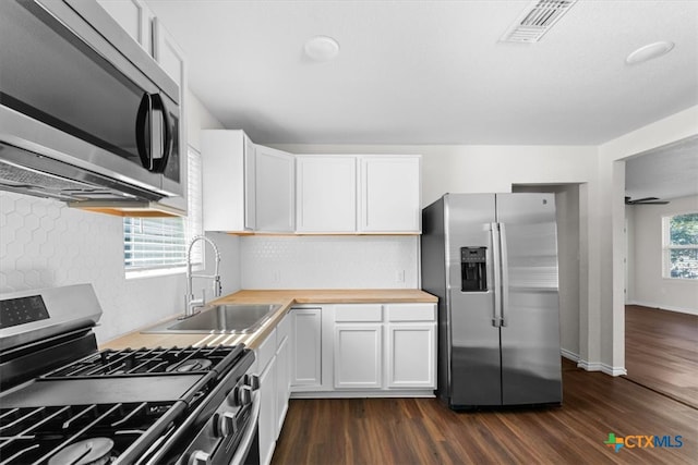 kitchen featuring white cabinets, sink, dark wood-type flooring, and appliances with stainless steel finishes