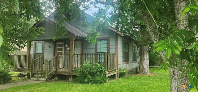 267 Illinois St, Bloomington, TX 77951 - back of house featuring a shingled roof and a lawn