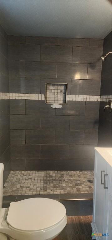 267 Illinois St, Bloomington, TX 77951 - full bathroom featuring tiled shower, toilet, and wood finished floors