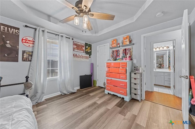 509 Sapphire Blvd, Hewitt, TX 76643 - bedroom with light wood finished floors, a tray ceiling, baseboards, and a ceiling fan