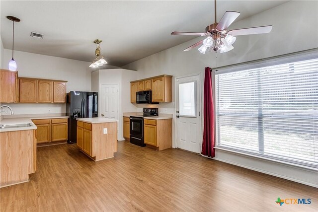 2154 Hidden Mdw, New Braunfels, TX 78130 - kitchen with visible vents, black appliances, wood finished floors, light countertops, and a sink