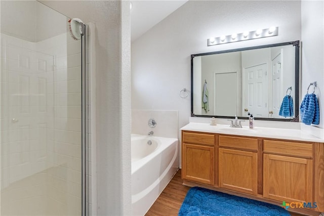 bathroom with vanity, wood-type flooring, and shower with separate bathtub