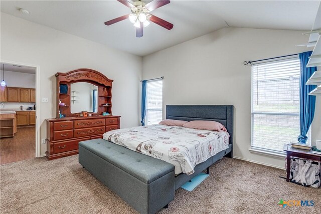 bedroom featuring ceiling fan, light colored carpet, and vaulted ceiling