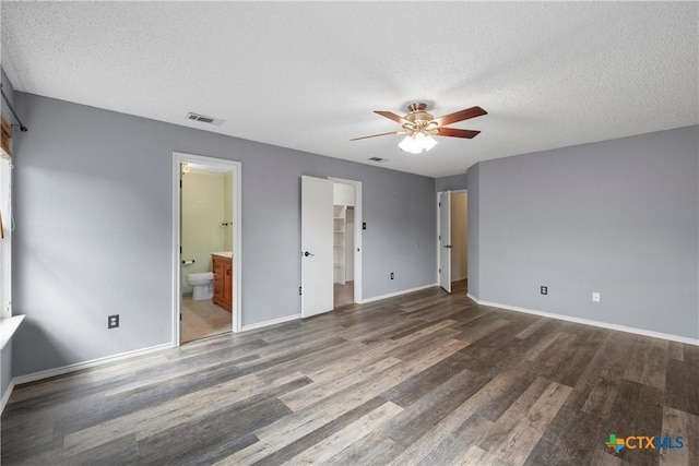 1007 Judy Ln, Copperas Cove, TX 76522 - unfurnished bedroom featuring wood finished floors, a textured ceiling, connected bathroom, a spacious closet, and ceiling fan