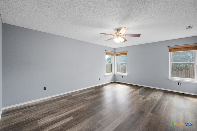 1007 Judy Ln, Copperas Cove, TX 76522 - empty room featuring healthy amount of natural light, a ceiling fan, dark wood-style floors, and a textured ceiling