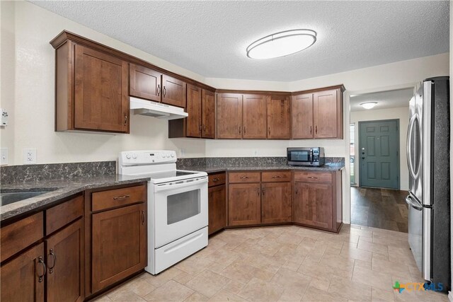 1007 Judy Ln, Copperas Cove, TX 76522 - kitchen featuring stainless steel appliances, under cabinet range hood, dark stone countertops, a textured ceiling, and light stone finish flooring