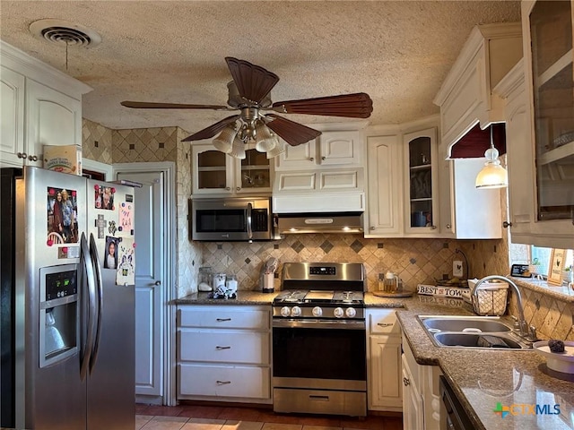 kitchen with appliances with stainless steel finishes, decorative light fixtures, sink, and white cabinets