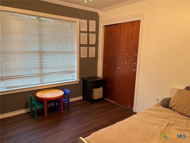 bedroom featuring dark hardwood / wood-style flooring, multiple windows, ornamental molding, and a closet