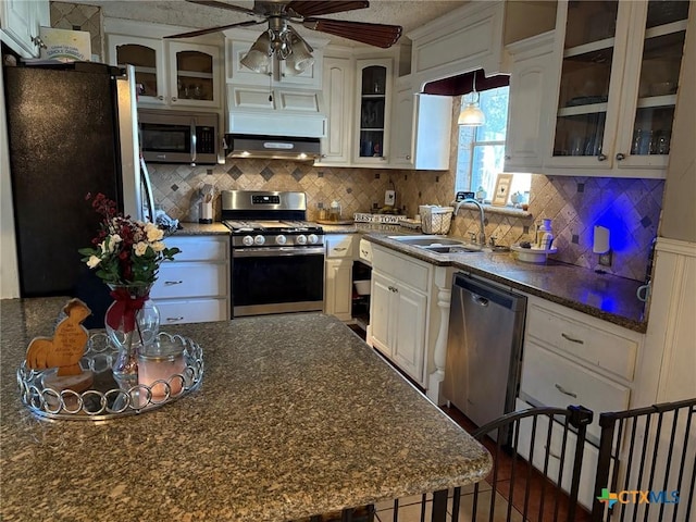 kitchen with pendant lighting, sink, appliances with stainless steel finishes, white cabinetry, and backsplash