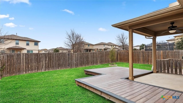 view of yard featuring a wooden deck and ceiling fan