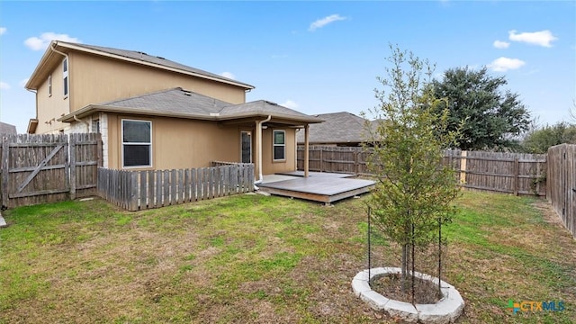 rear view of house featuring a yard and a deck