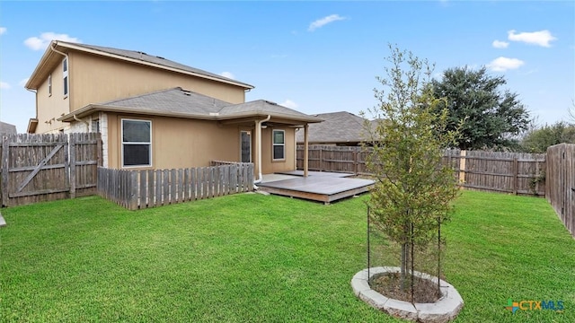 rear view of property with a wooden deck and a yard