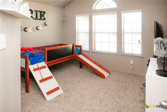 bedroom with carpet, multiple windows, and vaulted ceiling