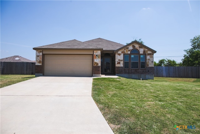 single story home featuring a garage and a front yard